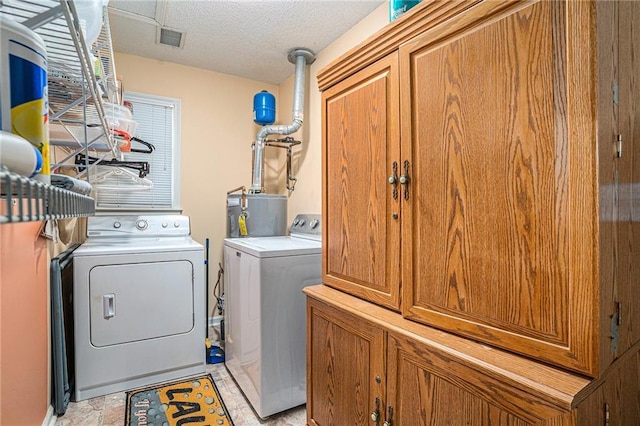 2130 Hampton Trl SE, Conyers, GA 30013 - laundry area featuring washer and dryer, cabinet space, and a textured ceiling