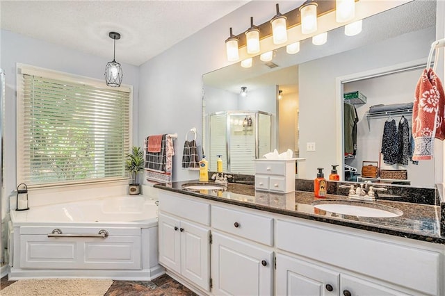 2130 Hampton Trl SE, Conyers, GA 30013 - full bathroom with a stall shower, double vanity, a bath, a spacious closet, and a textured ceiling