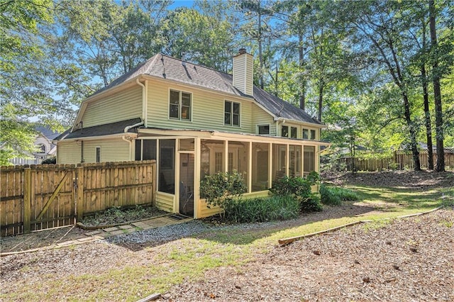 2130 Hampton Trl SE, Conyers, GA 30013 - back of property with a sunroom, a chimney, a fenced backyard, a gate, and a shingled roof
