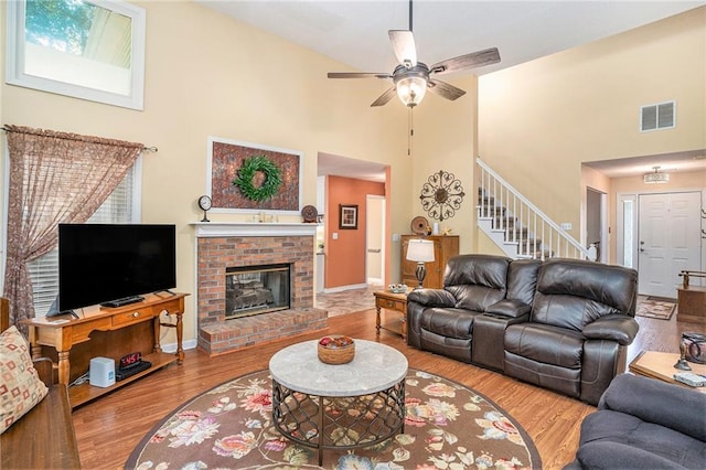 2130 Hampton Trl SE, Conyers, GA 30013 - living area featuring high vaulted ceiling, stairs, ceiling fan, wood finished floors, and a fireplace