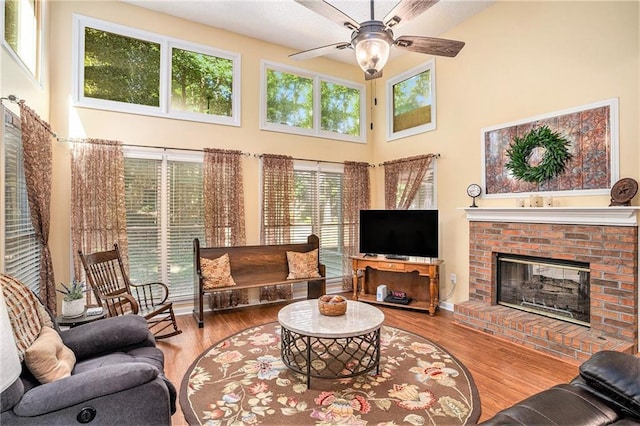 2130 Hampton Trl SE, Conyers, GA 30013 - living area featuring a towering ceiling, ceiling fan, plenty of natural light, wood finished floors, and a brick fireplace