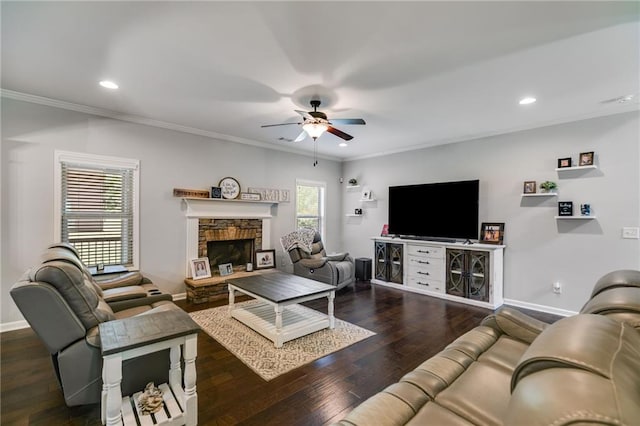 living room featuring a ceiling fan, baseboards, crown molding, a stone fireplace, and recessed lighting