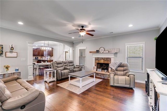 living room featuring ornate columns, ceiling fan, arched walkways, dark wood finished floors, and recessed lighting