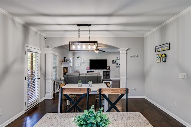 dining room featuring ornate columns, ceiling fan, dark wood-style flooring, baseboards, and crown molding
