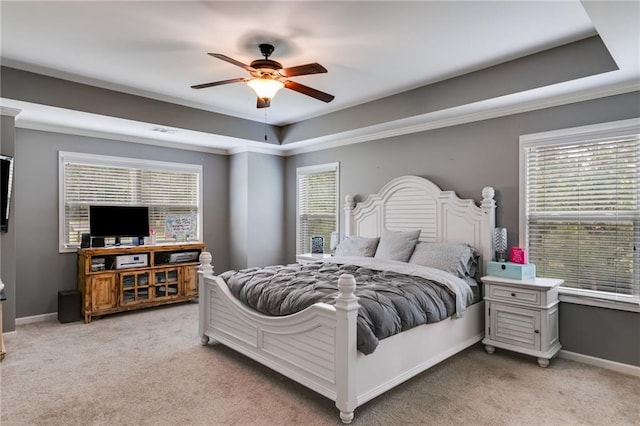 bedroom with light carpet, a tray ceiling, ceiling fan, and baseboards