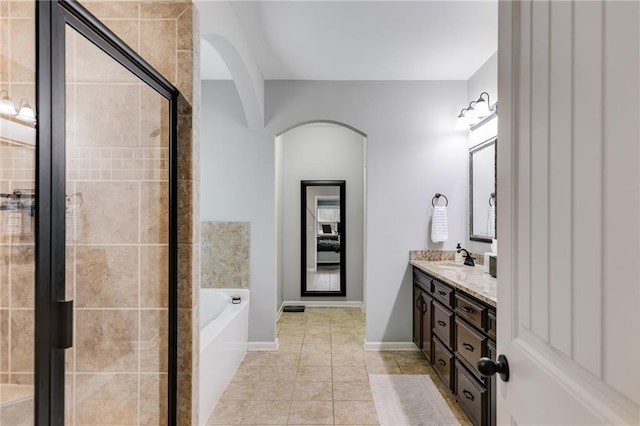 bathroom with a garden tub, tile patterned flooring, a shower stall, and double vanity