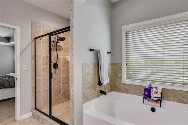 bathroom featuring a shower stall, ensuite bathroom, and a garden tub