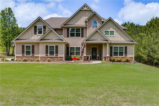 craftsman house with board and batten siding, stone siding, and a front lawn