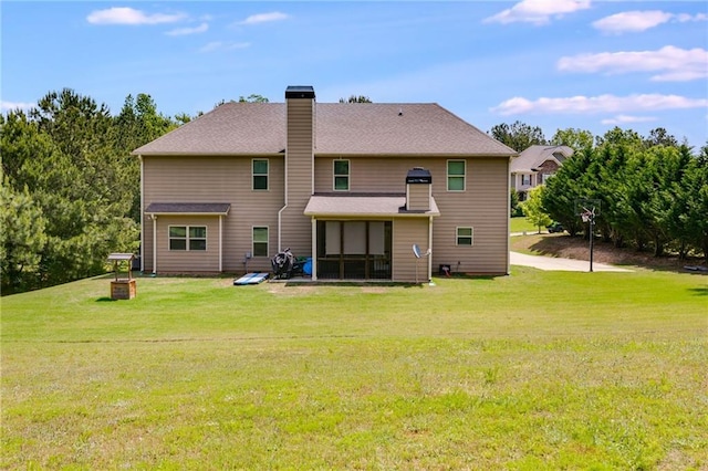 back of house featuring a lawn, a chimney, and a sunroom