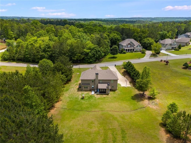 aerial view of property and surrounding area with a heavily wooded area