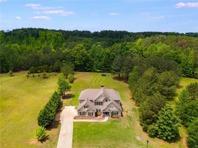 aerial view of property and surrounding area featuring a forest