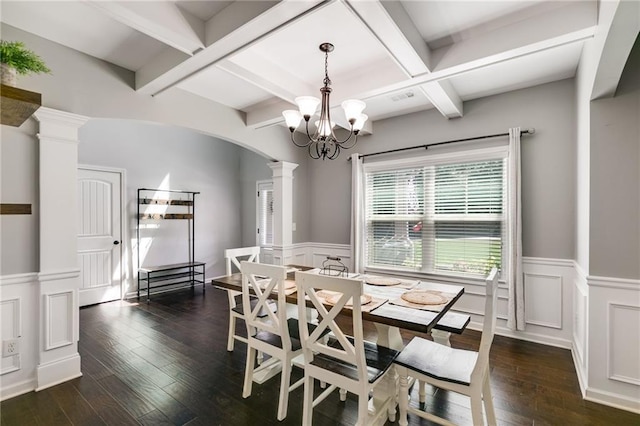 dining area featuring ornate columns, wainscoting, arched walkways, dark wood-type flooring, and a decorative wall