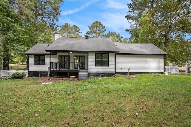 rear view of house featuring fence, a deck, a chimney, crawl space, and a lawn