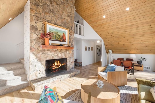 living room with wooden ceiling, a fireplace, light hardwood / wood-style flooring, and high vaulted ceiling