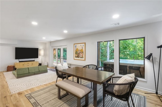 dining room with light wood-type flooring, french doors, and a wealth of natural light