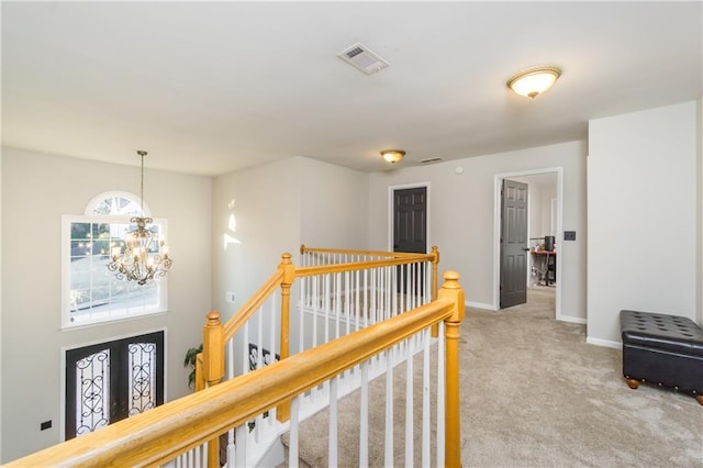 corridor featuring carpet flooring, visible vents, an upstairs landing, baseboards, and french doors