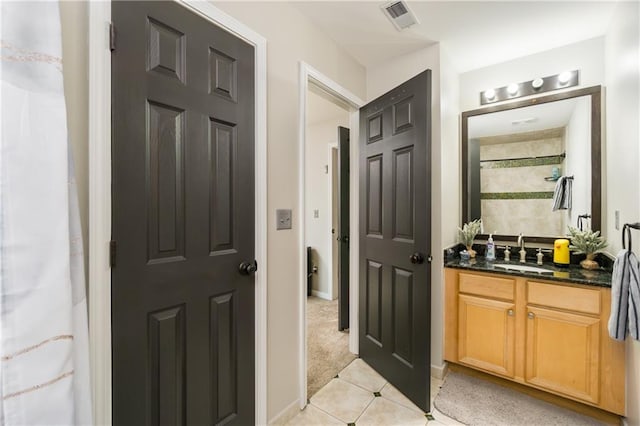 full bath with visible vents, baseboards, tile patterned flooring, a tile shower, and vanity