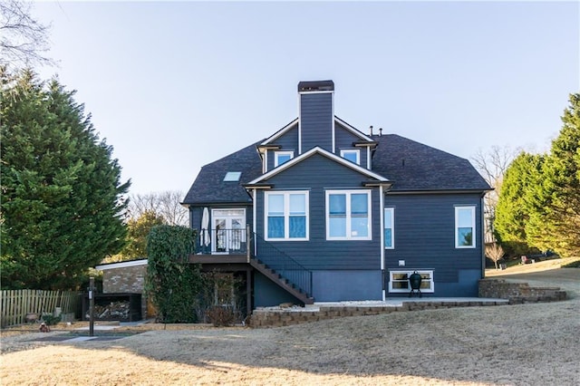 back of property featuring a chimney, stairway, fence, and a wooden deck