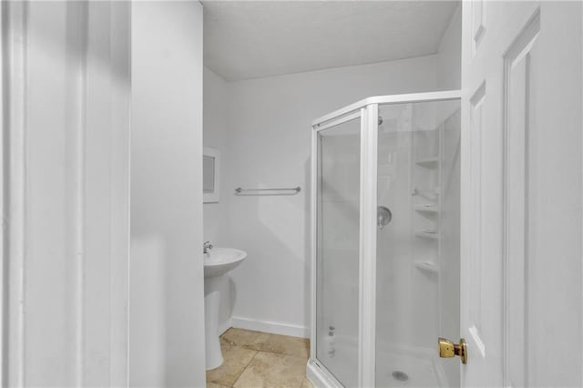 full bath featuring tile patterned flooring, a shower stall, and baseboards