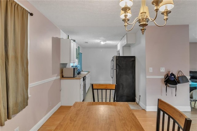 dining area with light wood-style floors and a textured ceiling