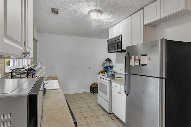 kitchen with white cabinets, visible vents, stainless steel appliances, and light countertops