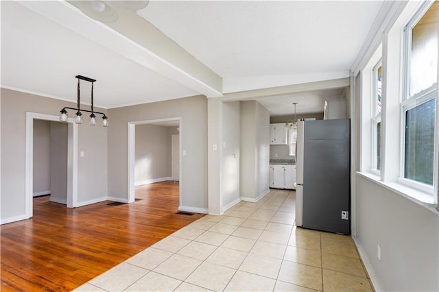 spare room featuring light tile patterned floors and baseboards