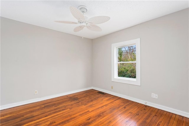 unfurnished room with visible vents, a ceiling fan, baseboards, and wood-type flooring