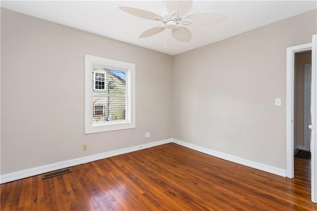 empty room with visible vents, a ceiling fan, baseboards, and hardwood / wood-style floors