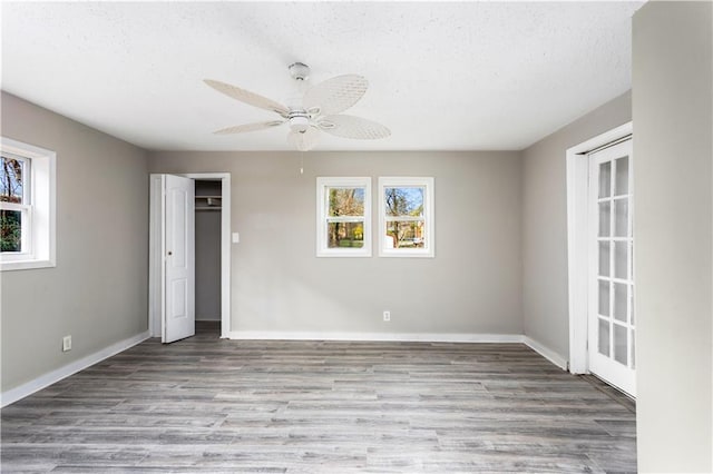 unfurnished bedroom with wood finished floors, baseboards, and a textured ceiling