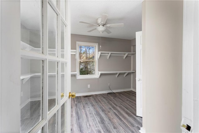 walk in closet featuring visible vents, a ceiling fan, and wood finished floors