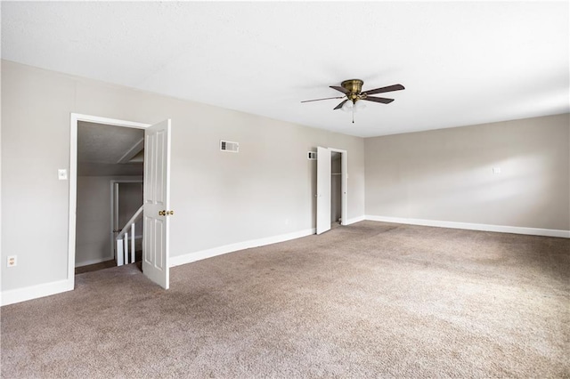 unfurnished room with carpet flooring, a ceiling fan, visible vents, and baseboards