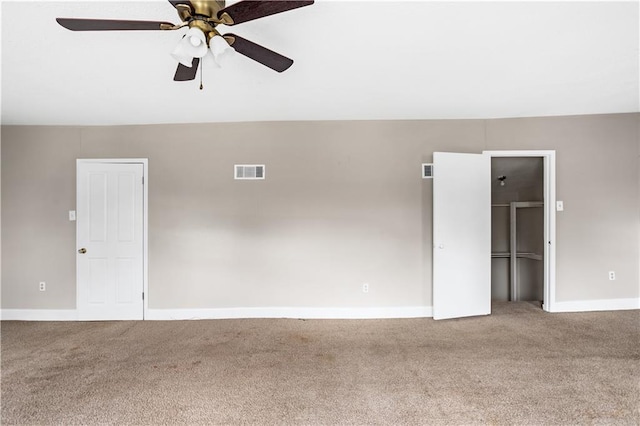 empty room with visible vents, carpet floors, baseboards, and ceiling fan