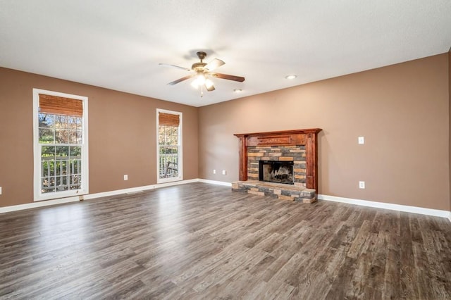 unfurnished living room with dark wood-type flooring, ceiling fan, and a fireplace