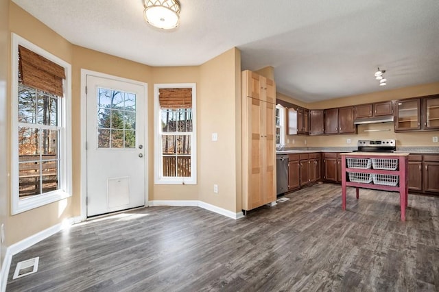 kitchen featuring under cabinet range hood, dark wood-style flooring, visible vents, light countertops, and appliances with stainless steel finishes