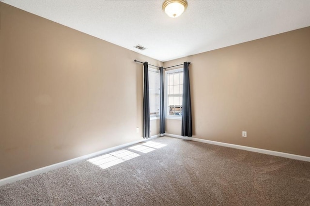 unfurnished room featuring carpet, visible vents, and baseboards