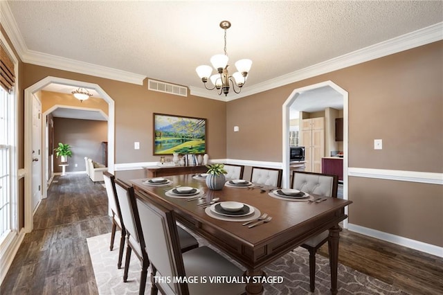 dining space featuring arched walkways, visible vents, dark wood finished floors, and an inviting chandelier