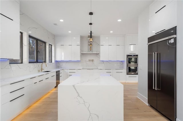 1678 Thomas Dr, Hoschton, GA 30548 - kitchen with high end fridge, modern cabinets, stainless steel double oven, white cabinetry, and a kitchen island