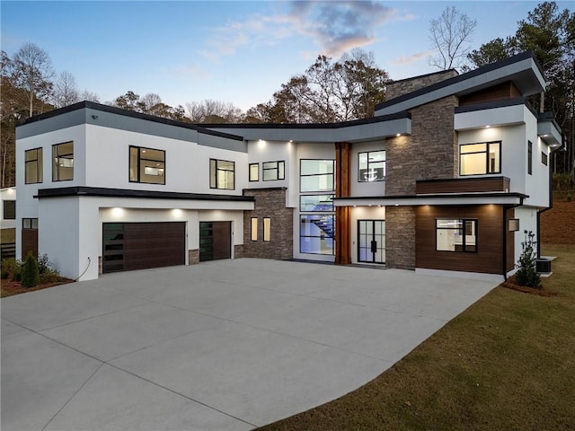 1678 Thomas Dr, Hoschton, GA 30548 - modern home featuring stone siding, driveway, a garage, and stucco siding