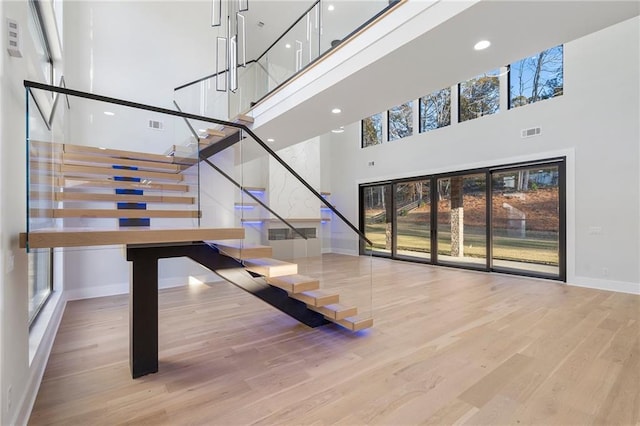 1678 Thomas Dr, Hoschton, GA 30548 - stairs with a towering ceiling, baseboards, wood finished floors, and recessed lighting