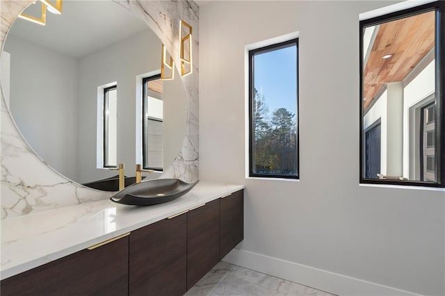 1678 Thomas Dr, Hoschton, GA 30548 - bathroom featuring marble finish floors, vanity, baseboards, and backsplash