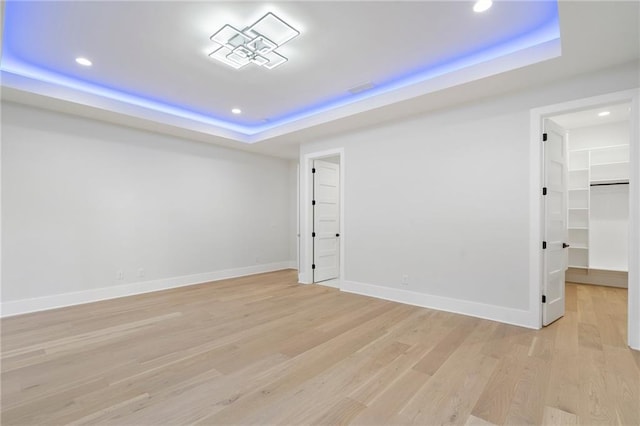 1678 Thomas Dr, Hoschton, GA 30548 - unfurnished room featuring a tray ceiling, recessed lighting, light wood-type flooring, and baseboards
