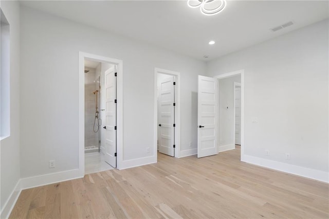 1678 Thomas Dr, Hoschton, GA 30548 - unfurnished bedroom featuring light wood-style flooring, a spacious closet, baseboards, recessed lighting, and connected bathroom