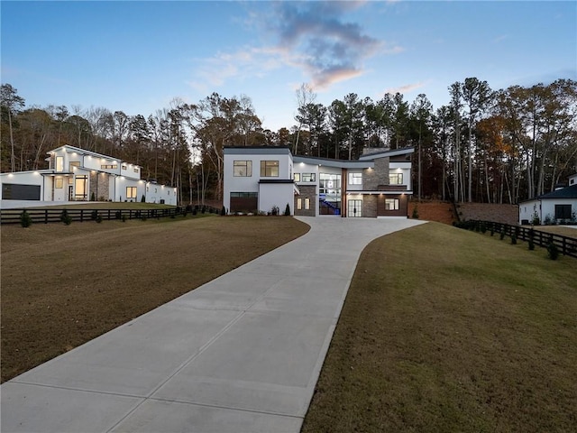1678 Thomas Dr, Hoschton, GA 30548 - contemporary house featuring concrete driveway, stucco siding, and view of wooded area