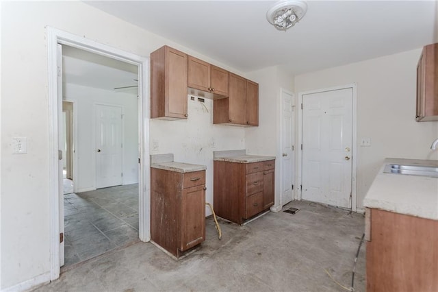 1167 Sanders Dr, Morrow, GA 30260 - kitchen with a sink, brown cabinetry, light countertops, and concrete floors