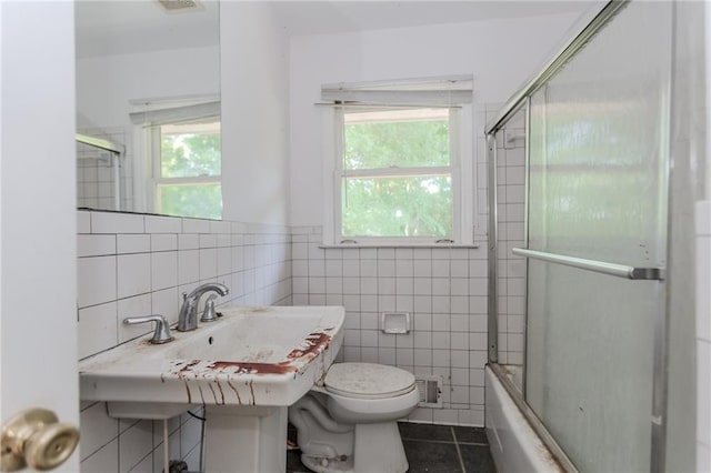 1167 Sanders Dr, Morrow, GA 30260 - bathroom with toilet, tile walls, tile patterned flooring, and combined bath / shower with glass door