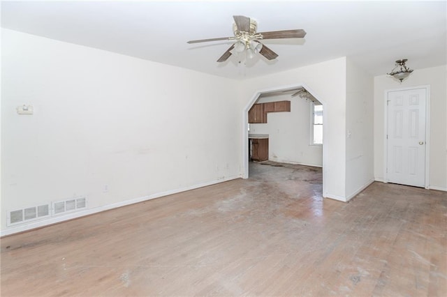 1167 Sanders Dr, Morrow, GA 30260 - unfurnished living room featuring wood finished floors, ceiling fan, baseboards, and arched walkways