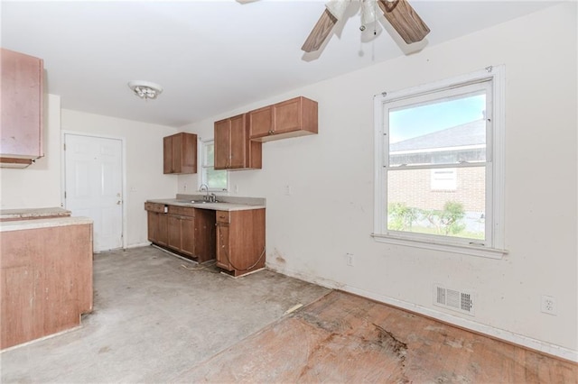 1167 Sanders Dr, Morrow, GA 30260 - kitchen featuring ceiling fan, brown cabinetry, light countertops, and a sink