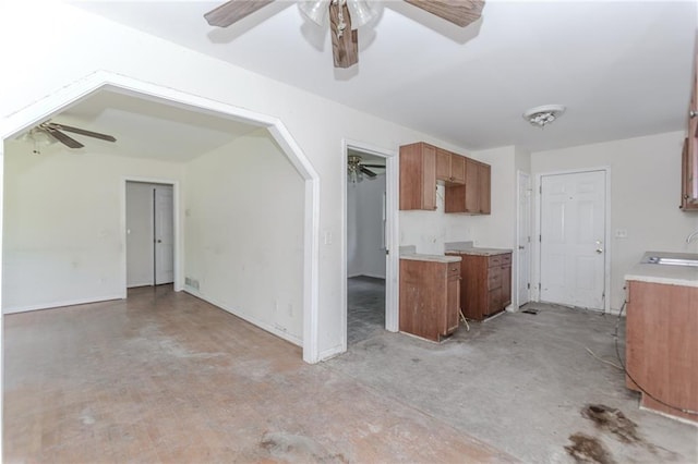 1167 Sanders Dr, Morrow, GA 30260 - kitchen with ceiling fan, brown cabinets, a sink, light countertops, and baseboards