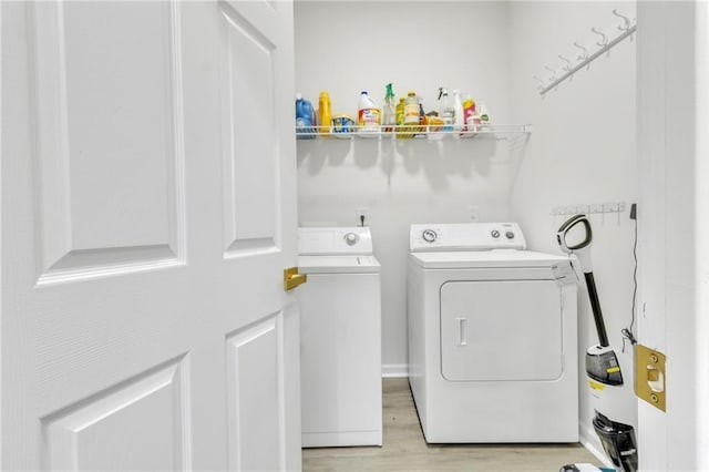 laundry area with washer and dryer and light wood-type flooring