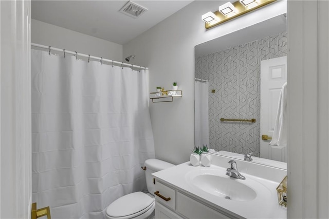 bathroom featuring toilet, vanity, and a shower with shower curtain